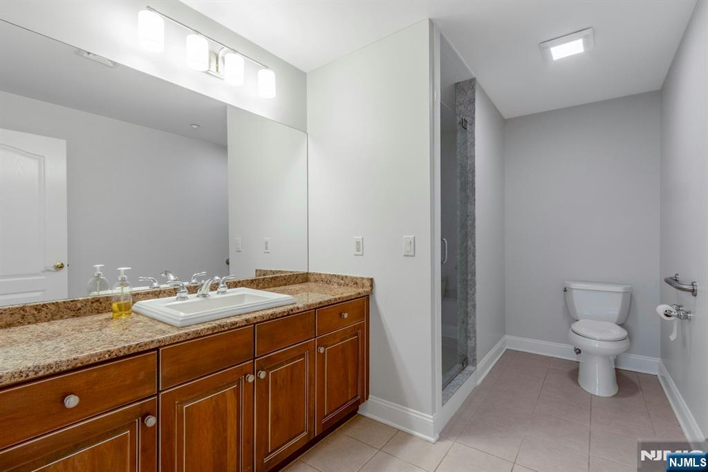 5401 Rio Vista Drive Mahwah, NJ 07430 - Photo 17 of 26 a spacious bathroom with a granite countertop sink a toilet and a mirror