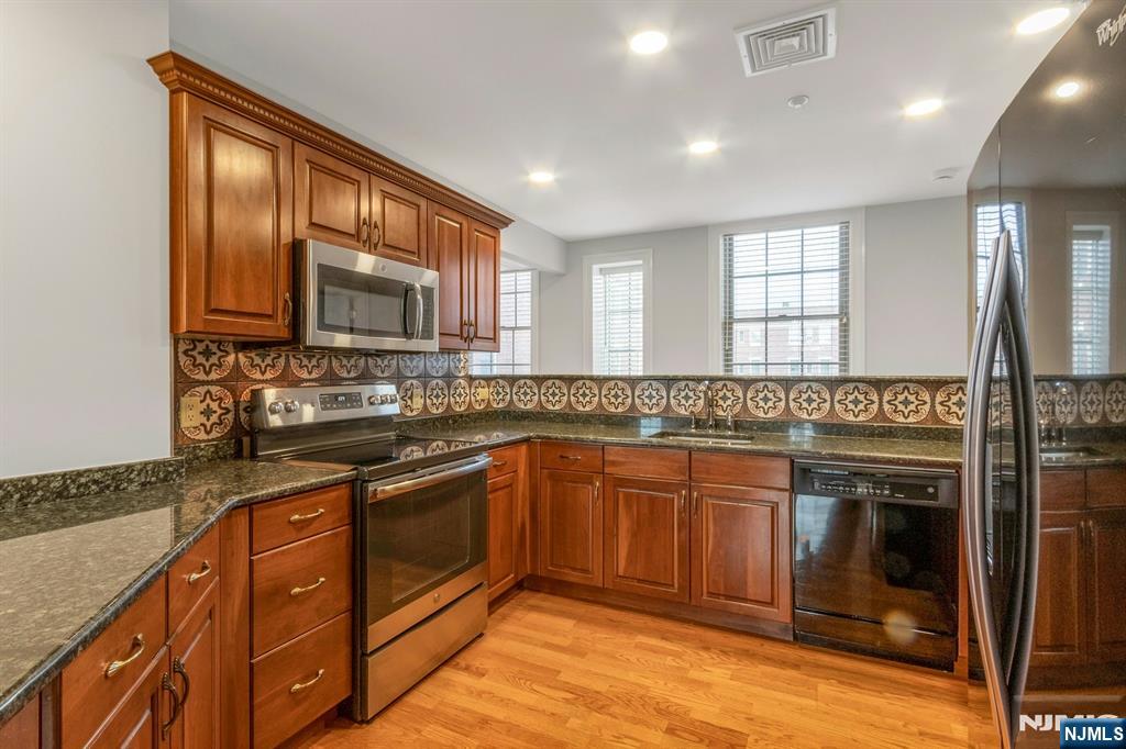 5401 Rio Vista Drive Mahwah, NJ 07430 - Photo 6 of 26 a kitchen with stainless steel appliances granite countertop a stove a sink and a microwave