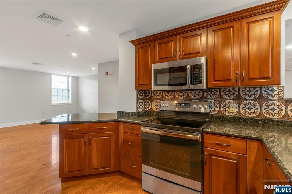 5401 Rio Vista Drive Mahwah, NJ 07430 - Photo 8 of 26 a kitchen with granite countertop stainless steel appliances a stove sink and microwave