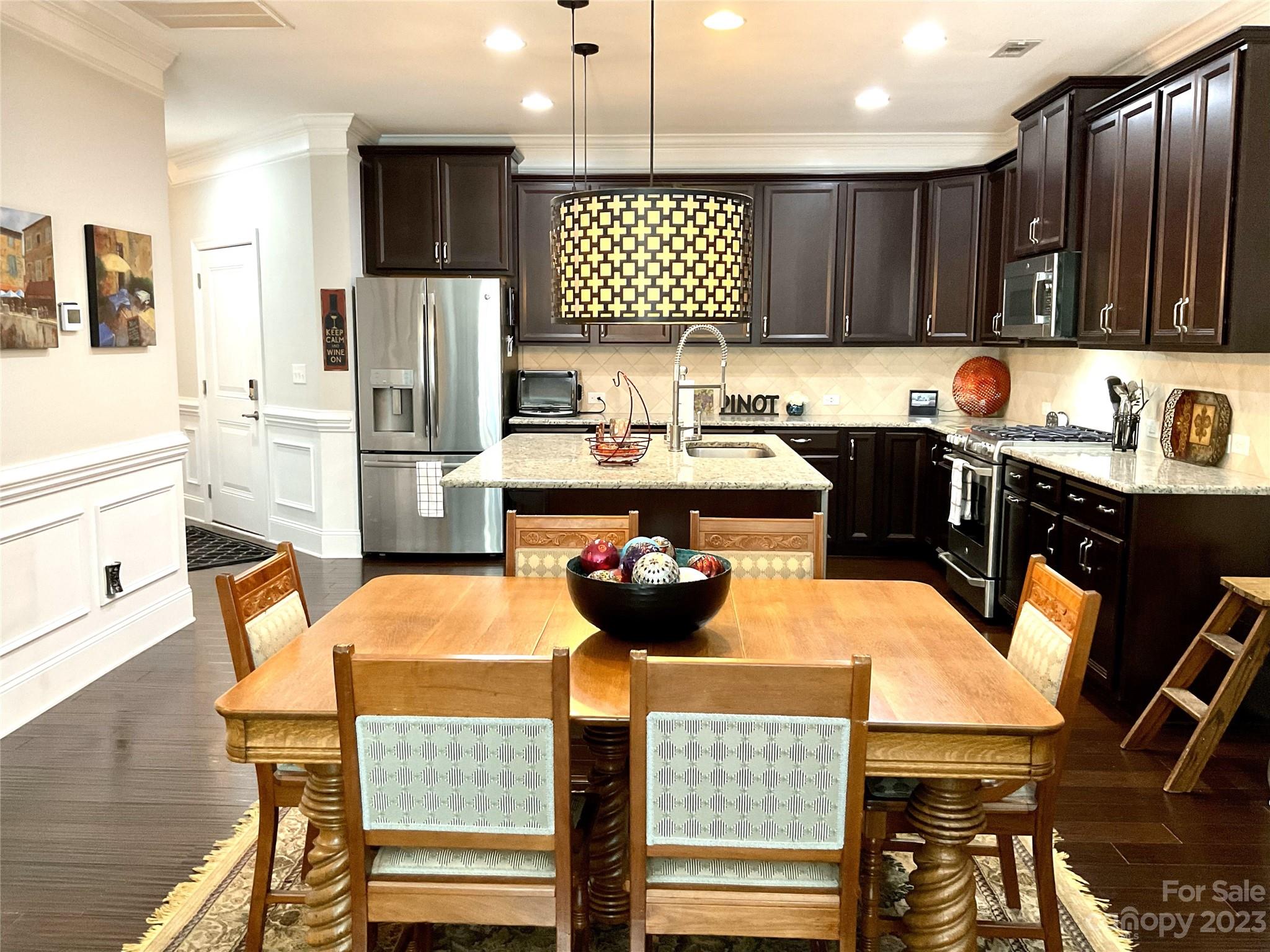 902 Ospre Lane Fort Mill, SC 29708 - Photo 12 of 44 a kitchen with stainless steel appliances a dining table chairs refrigerator and cabinets