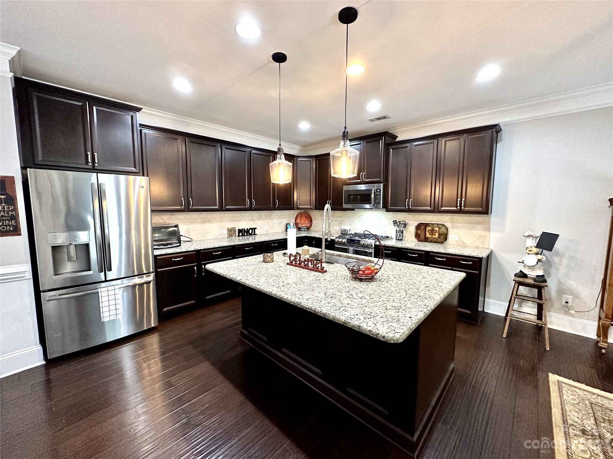 902 Ospre Lane Fort Mill, SC 29708 - Photo 8 of 44 a kitchen with kitchen island granite countertop a sink refrigerator and wooden floor