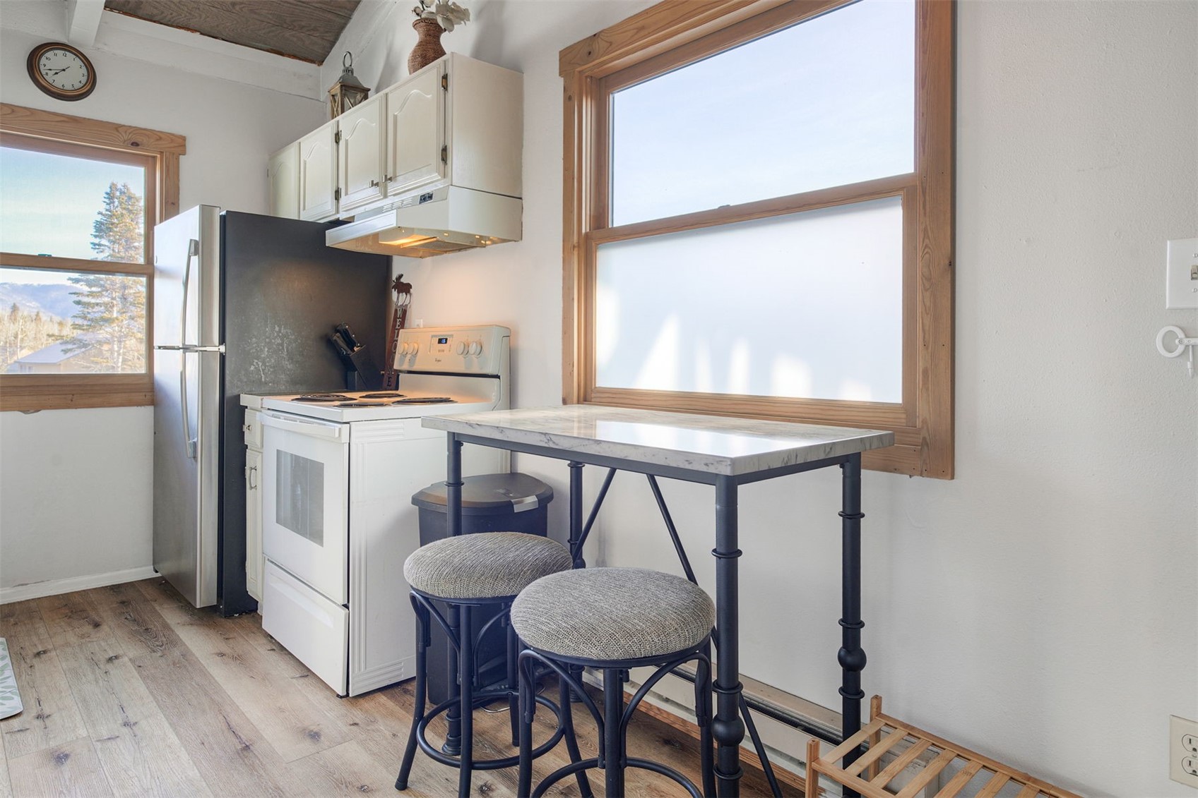 8018 Ryan Gulch Road, Unit B9 Silverthorne, CO 80498 - Photo 6 of 17 a kitchen with stainless steel appliances a table chairs and a refrigerator