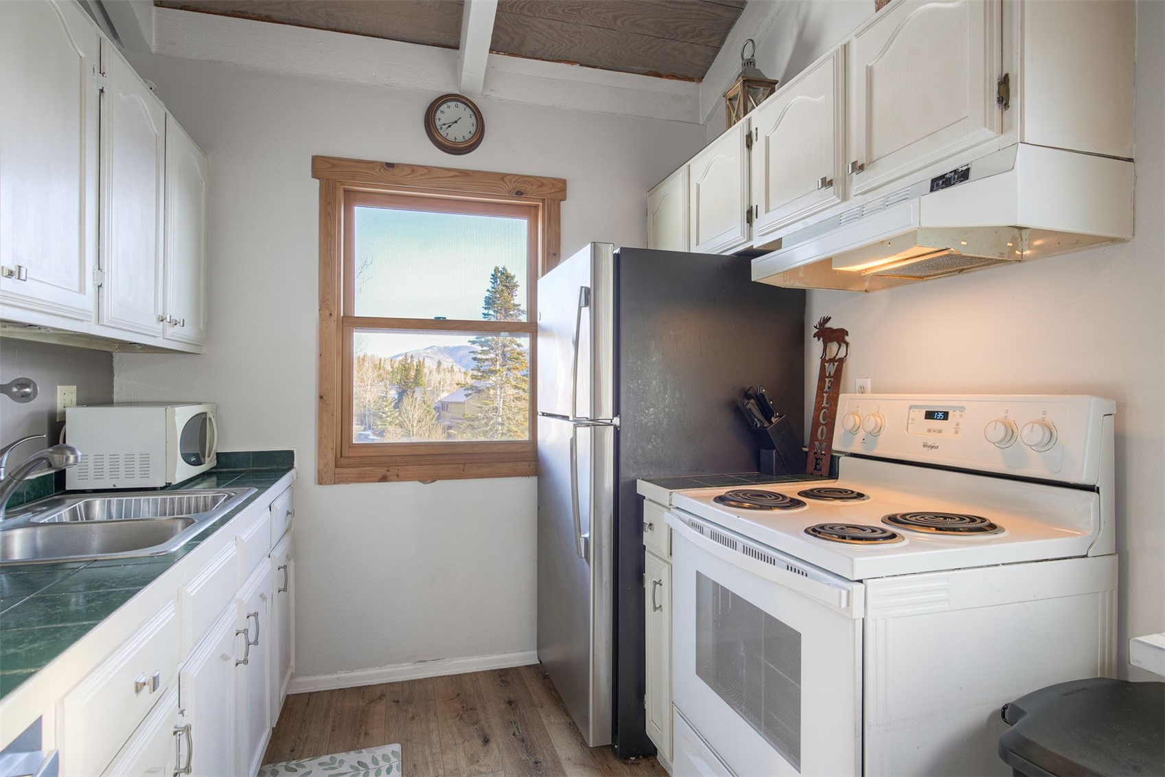 8018 Ryan Gulch Road, Unit B9 Silverthorne, CO 80498 - Photo 9 of 17 a kitchen with granite countertop a refrigerator stove and sink