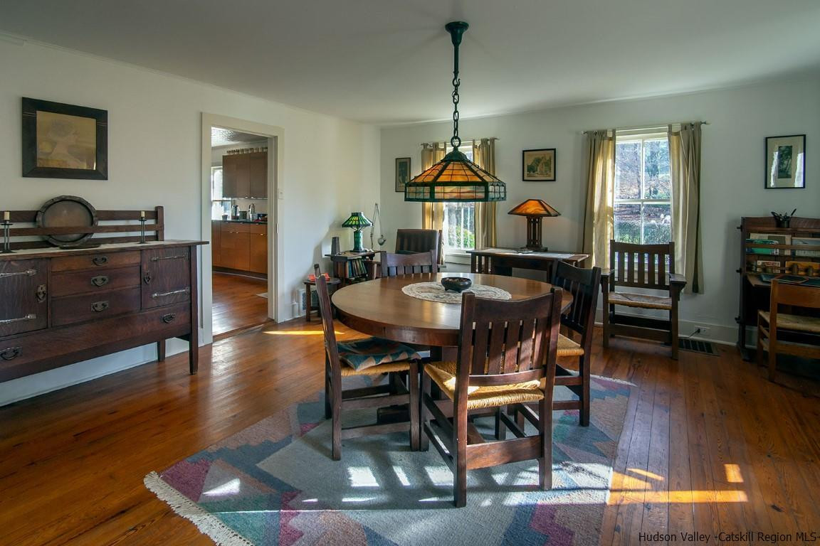174 Peak Road Stone Ridge, NY 12484 - Photo 9 of 29 a dining room with furniture a chandelier and wooden floor