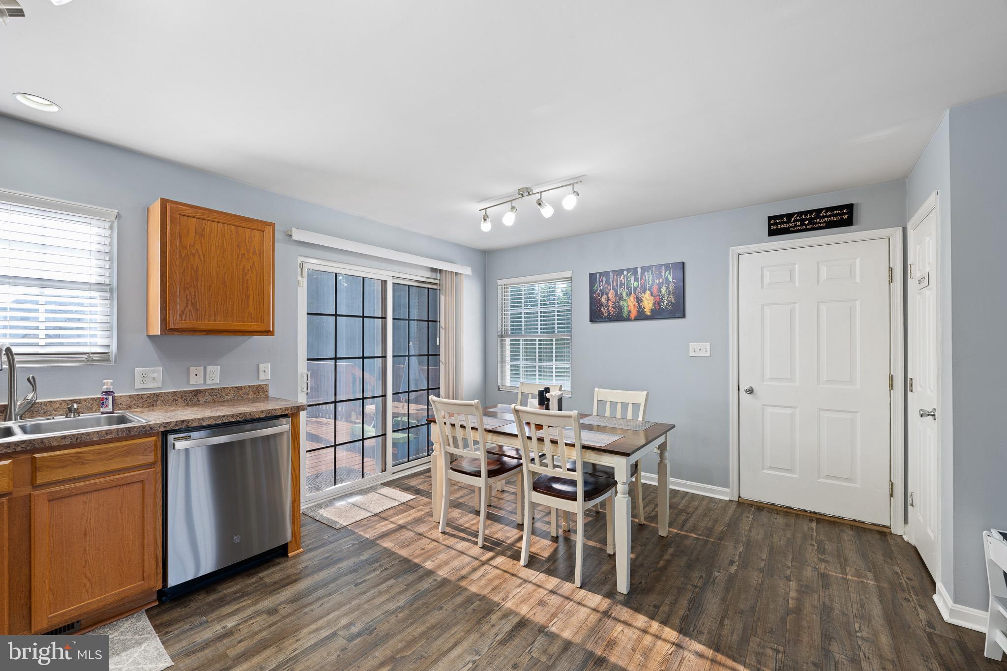 70 West Deer Trail Road Clayton, DE 19938 - Photo 12 of 25 a view of a kitchen with a dining table chairs and wooden floor