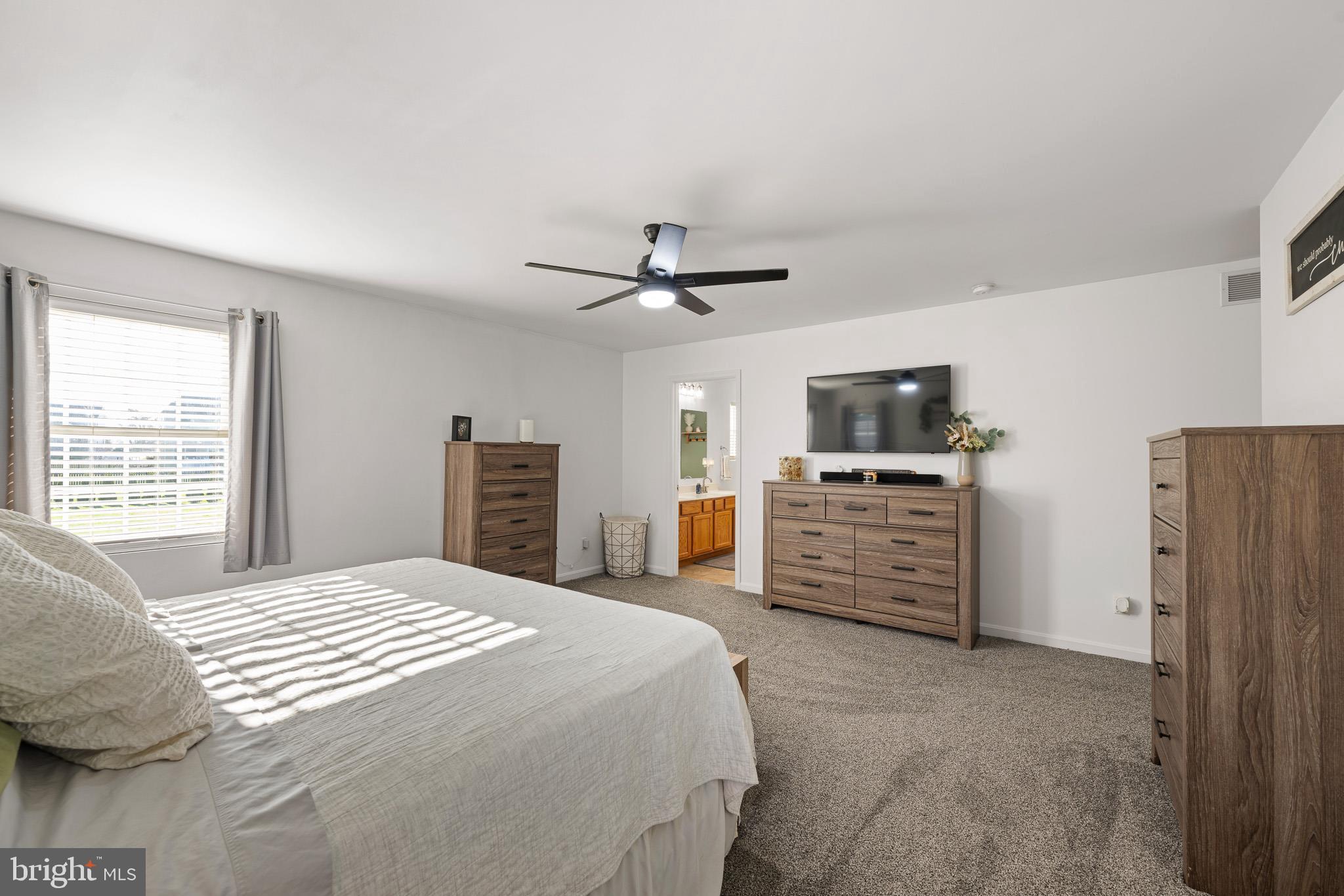 70 West Deer Trail Road Clayton, DE 19938 - Photo 20 of 25 a bedroom with a bed dresser and a flat tv screen
