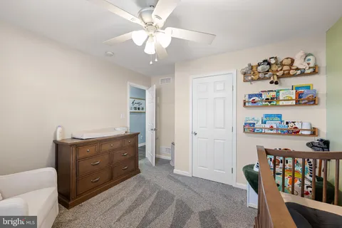 a room with a baby crib and a dresser