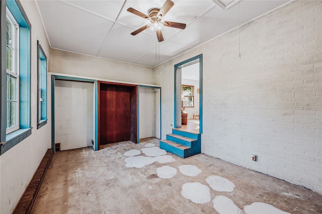209 Cleveland Pike Road Westminster, SC 29693 - Photo 24 of 30 A versatile room awaits transformation, featuring exposed brick, wood-framed windows, and a ready-to-customize closet.