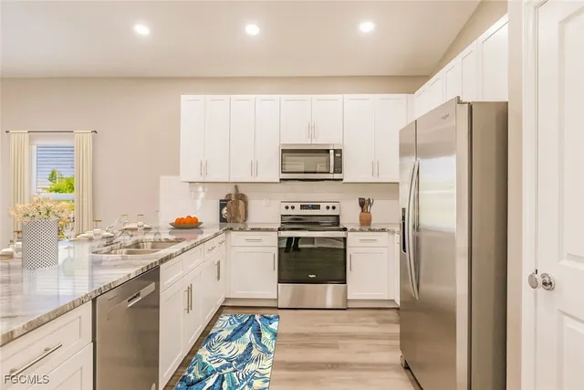 a kitchen with a sink a refrigerator a microwave and cabinets