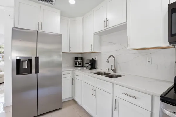 a kitchen with white cabinets and stainless steel appliances