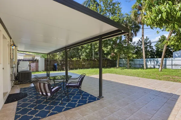 a view of a patio with a table chairs and backyard