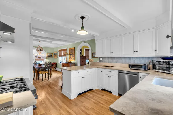a large kitchen with cabinets a sink a window and stainless steel appliances