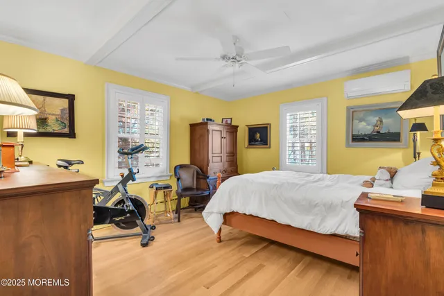 a bedroom with a bed a table and windows