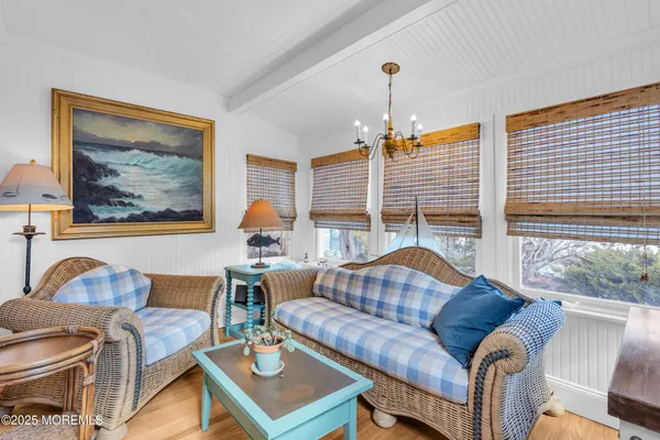 a living room with furniture a large window and a chandelier