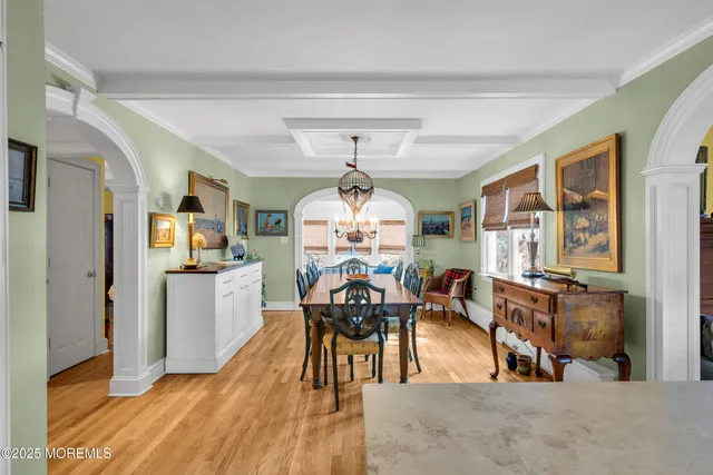 a view of a dining room and livingroom with furniture wooden floor a chandelier