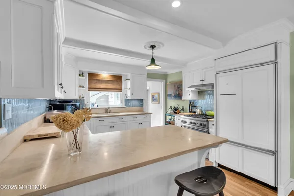 a kitchen with stainless steel appliances granite countertop a sink refrigerator and cabinets