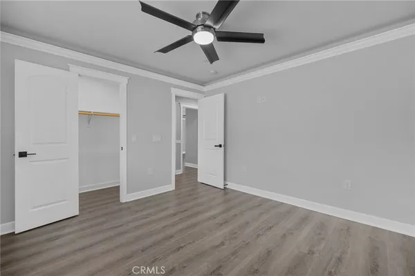 an empty room with wooden floor a ceiling fan and closet