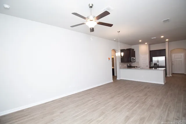 a view of a livingroom with a ceiling fan & wooden floor