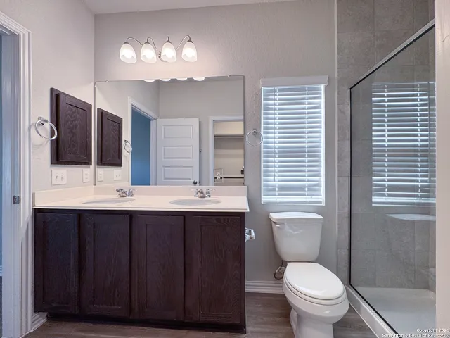 a bathroom with a shower sink vanity and toilet