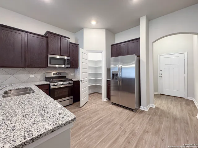 a kitchen with stainless steel appliances granite countertop a sink stove and refrigerator