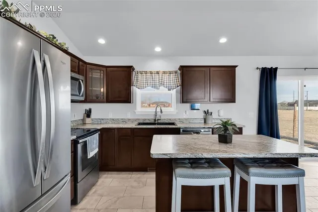a kitchen with granite countertop a sink and steel appliances