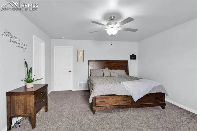 a bedroom with a bed a couch and a potted plant