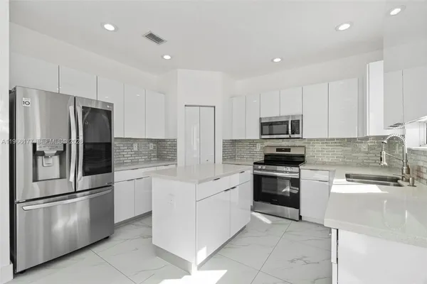 a kitchen with cabinets stainless steel appliances and a counter space