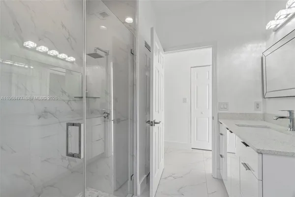 a bathroom with a shower sink and mirror