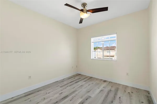 an empty room with a window and ceiling fan