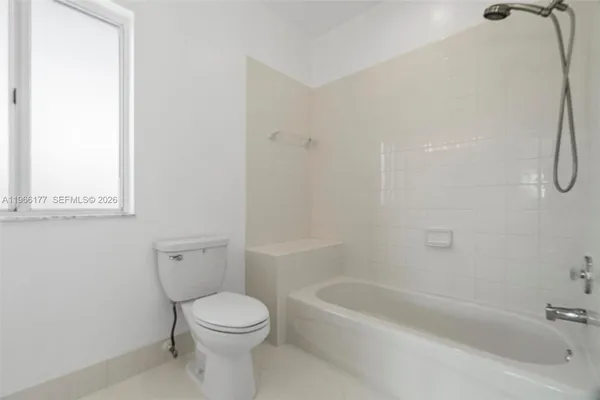 a white toilet sitting next to a bath tub