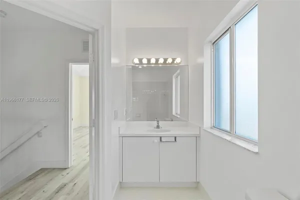 a bathroom with a light fixture a sink and a mirror
