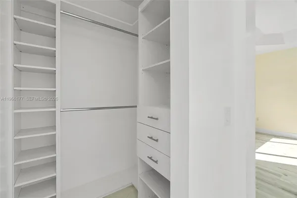 a view of walk in closet with empty racks