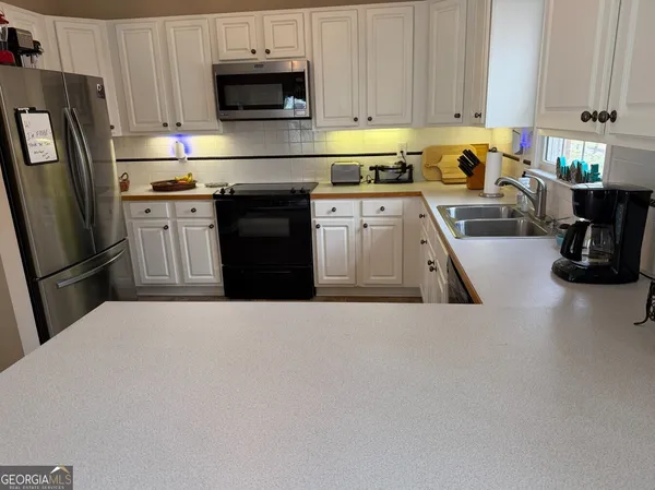 a view of a livingroom with lounge chair and windows
