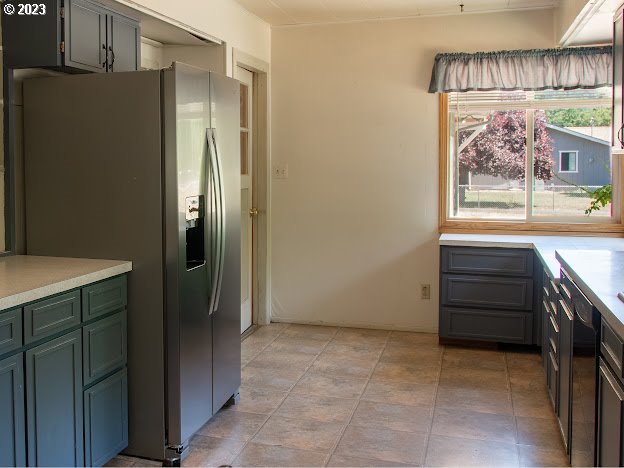 589 Lockwood Road Roseburg, OR 97471 - Photo 6 of 32 a view of a refrigerator in kitchen and wooden cabinets