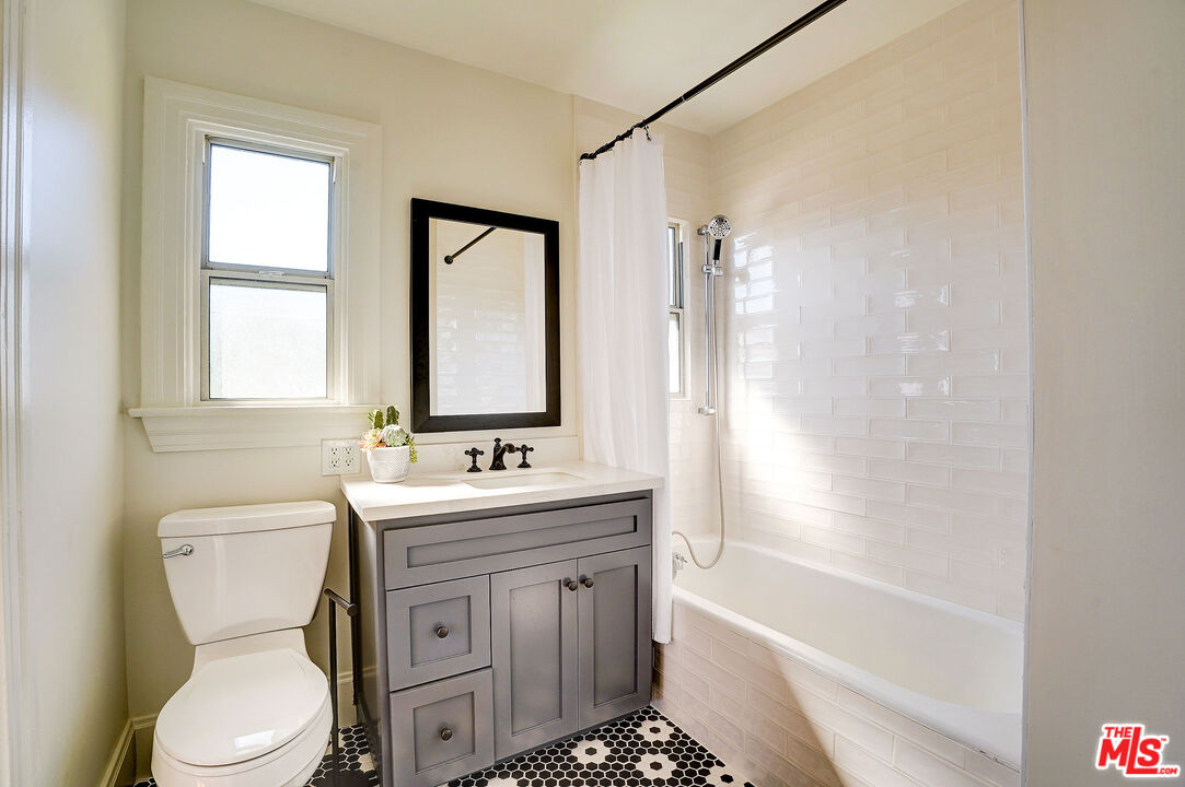 1944 Virginia Road Los Angeles, CA 90016 - Photo 18 of 36 a bathroom with a granite countertop toilet a sink and a bathtub