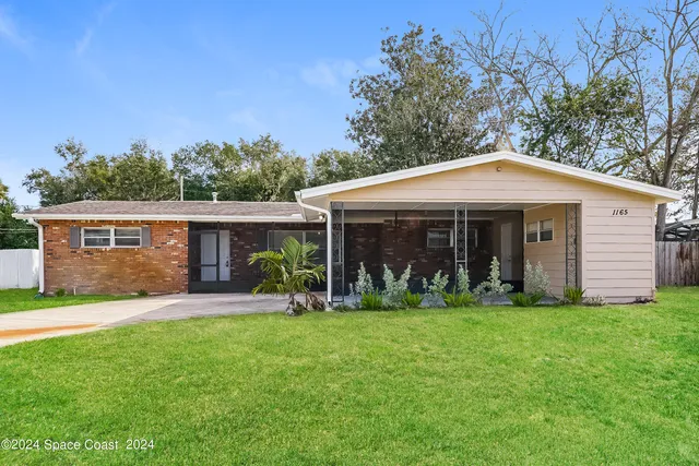 a front view of a house with a yard and trees