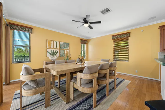 a kitchen with stainless steel appliances granite countertop a refrigerator a stove top oven and a sink with wooden floor