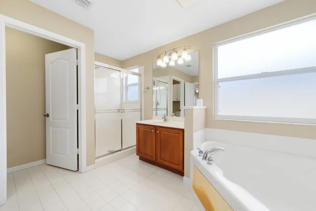 a view of a big room with windows and ceiling fan