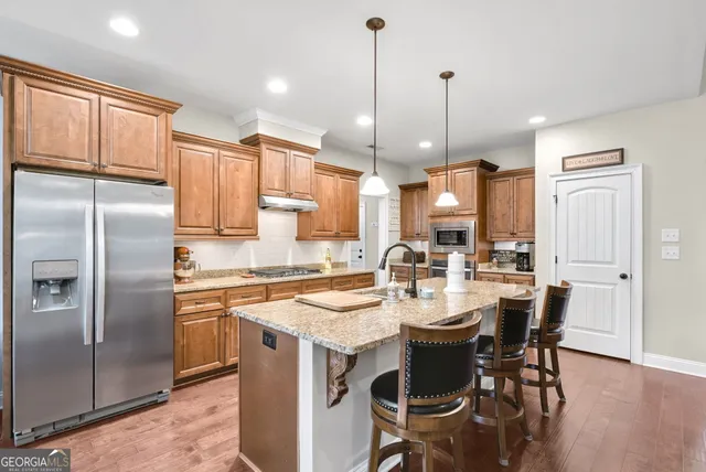 a kitchen with a dining table chairs refrigerator and microwave