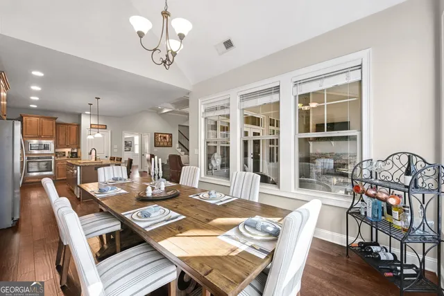 a view of a dining room with furniture a chandelier and wooden floor