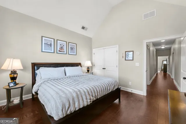 a spacious bedroom with a bed and a lamp on table