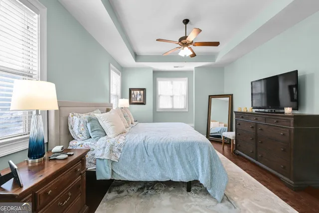 a bedroom with a bed and a flat tv screen on dresser