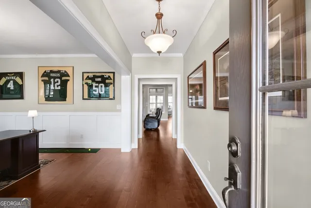 a view of a hallway with wooden floor and windows