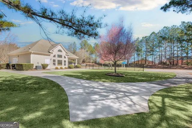 a view of a white house with a big yard and potted plants