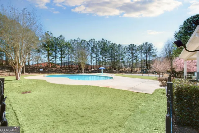 a view of yard with swimming pool and green space