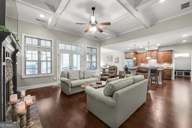 a living room with furniture kitchen view and a large window