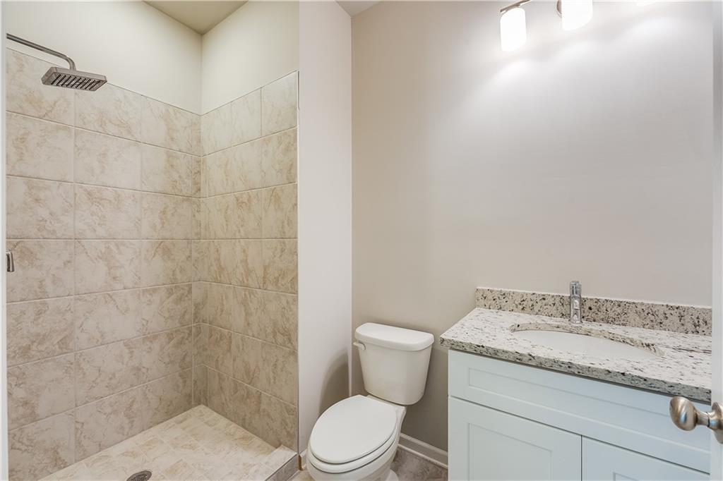 960 Lawton Street Southwest Atlanta, GA 30310 - Photo 11 of 16 a bathroom with a granite countertop toilet and a shower
