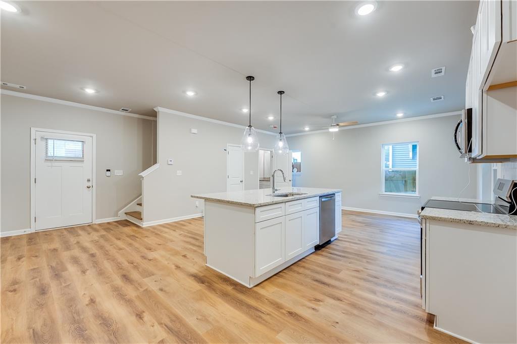 960 Lawton Street Southwest Atlanta, GA 30310 - Photo 2 of 16 a large white kitchen with a large island oven a sink stainless steel appliances and cabinets