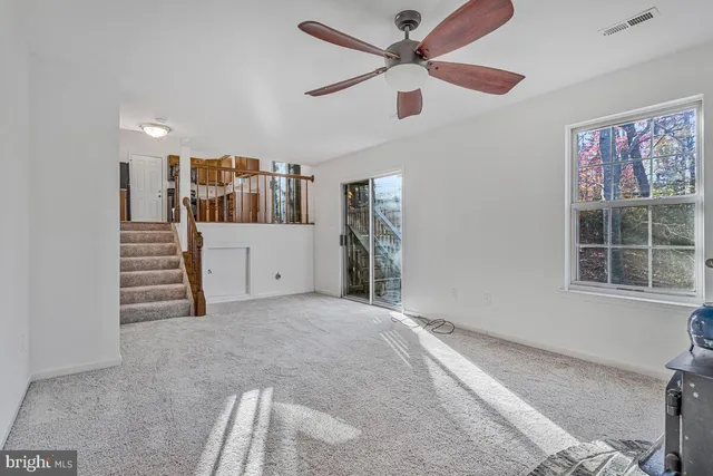 an empty room with a chandelier fan