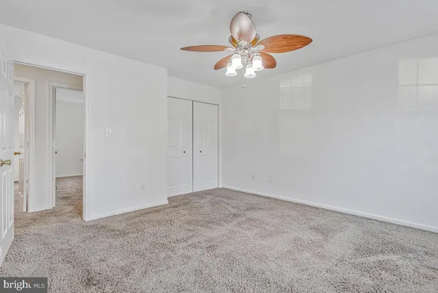 a view of a livingroom with a ceiling fan and window
